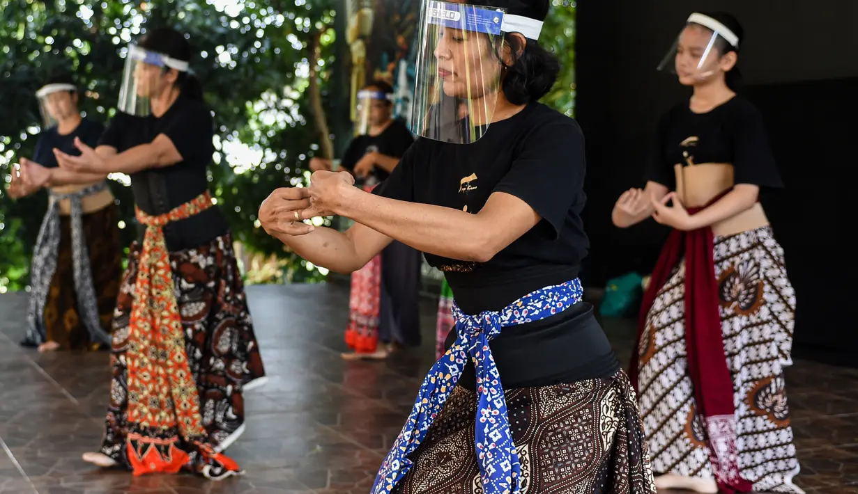 Anggota kelompok tari Surya Kirana mengenakan pelindung wajah mempraktikkan tarian tradisional Jawa klasik di Taman Mini Indonesia Indah (TMII), Jakarta, 11 Juli 2020. Mereka mengadakan latihan mingguan dengan mengikuti protokol kesehatan setelah TMII dibuka kembali. (Xinhua/Agung Kuncahya B.)