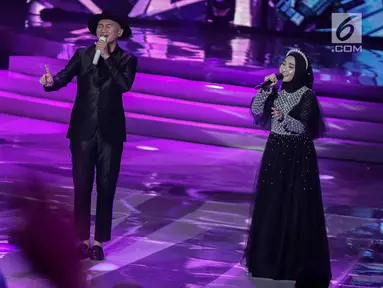 Penampilan Anji dan Fatin Shidqia Lubis dalam malam puncak Puteri Muslimah Asia 2018 di Jakarta, Senin (7/5). Puteri Muslimah Asia 2018 diikuti berbagai negara di Asia. (Liputan6.com/Faizal Fanani)