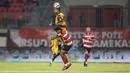 Pemain Persija Jakarta, Emaxwell (atas) berduel dengan pemain Madura United pada lanjutan BRI Super League 2025/2026 di Stadion Gelora Ratu Pamelingan, Jumat (24/10/2025) malam WIB. (Bola.com/Abdul Aziz).