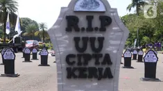 Puluhan nisan berjejer rapi di sekitar area Monas, Jakarta, pada Hari Buruh Internasional, Sabtu (1/5/2021). Nisan hitam itu dihiasi tulisan yang mewakili perasaan para buruh, Antara lain RIP PHK Murah, Bebasnya Outsourcing, RIP Cuti Hamil, RIP Satuan Upah-Perjam. (Liputan6.com/Angga Yuniar)