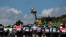 Penonton naik di atas crane saat menyambut pebalap yang berlomba di Etape1 Tour de France antara Mont-Saint-Michel dan Utah Beach Sainte-Marie-du-Mont, Normandy, (2/7/2016). (AFP/Kenzo Tribouillard)