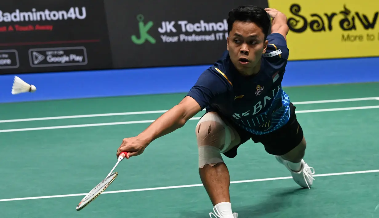 Pebulu tangkis tunggal putra Indonesia, Anthony Sinisuka Ginting berusaha mengembalikan bola saat menghadapi wakil Denmark, Anders Antonsen pada laga final Singapore Open 2023 di Singapore Indoor Stadium, Singapura, Minggu (11/6/2023). Anthony Ginting sukses menjadi juara setelah menang dua game langsung 21-16, 21-13. (AFP/Roslan Rahman)