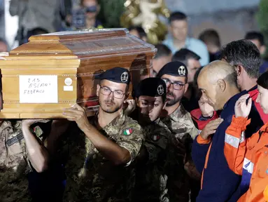 Tentara Italia menggotong peti mati pada upacara pemakaman korban gempa bumi yang meratakan kota di Amatrice, Italia tengah, Selasa (30/8). Hampir 300 orang tewas saat gempa bumi 6,2 SR melanda Amatrice dan sekitarnya 24 Agustus lalu. (REUTERS/Max Rossi)