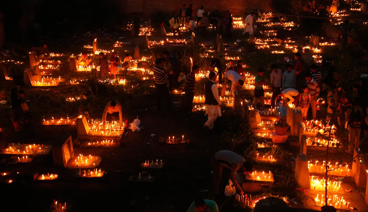 Sejumlah warga Kashmir menyalakan lilin di pemakaman keluarga dan saudara mereka saat memperingati Shab-e-Barat di pinggiran Srinagar, Kashmir (11/5). (AP Photo / Mukhtar Khan)