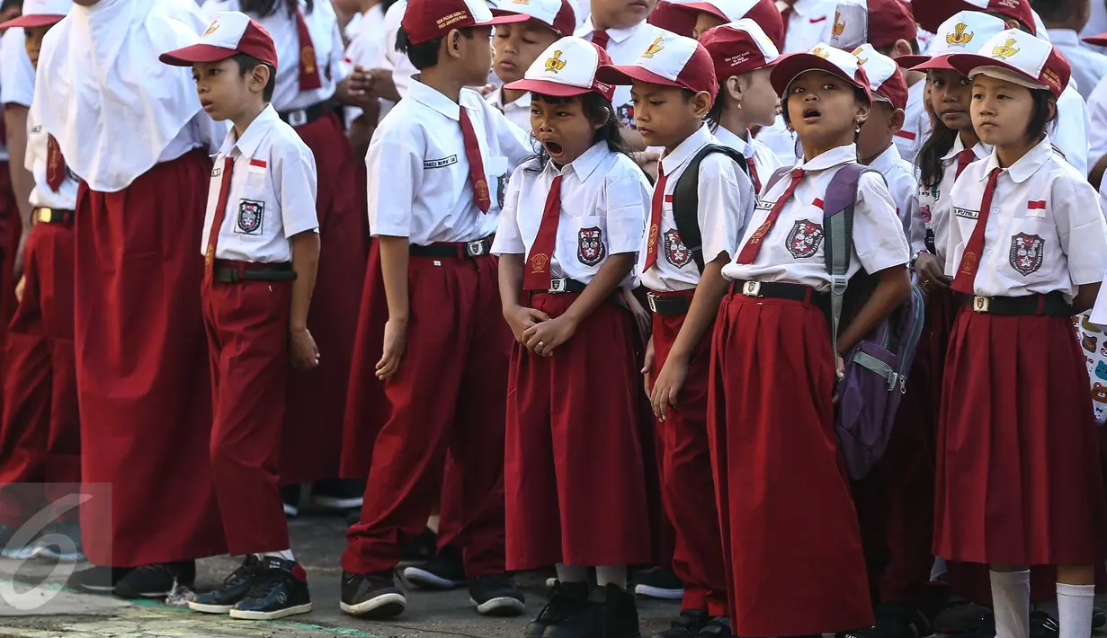 Seorang siswi menguap ketika upacara pada hari pertama sekolah di SDN Pasar Baru 05, Jakarta, Senin (18/7). Usai libur Idul Fitri, para siswa kembali beraktivitas mengikuti pelajaran di sekolah untuk tahun ajaran 2015-2016. (Liputan6.com/Faizal Fanani)