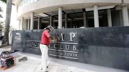 Pekerja mencopot nama 'Trump' dari papan sebuah hotel mewah di Panama, Senin (5/3). Pengusaha Siprus Orestes Fintiklis yang memiliki saham mayoritas hotel tersebut mengatakan, terjadi sengketa komersial yang tak terkendali. (AP/Arnulfo Franco)