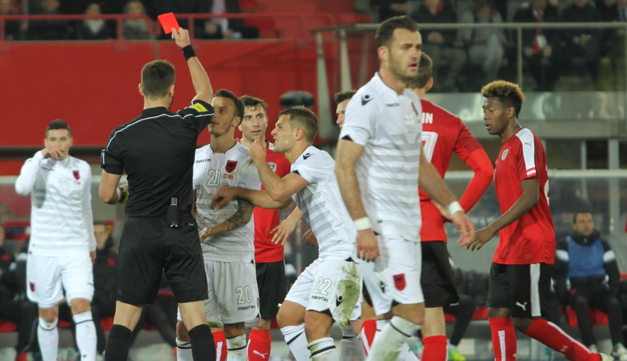 Wasit Ivan Kruzliak asal Slowakia mengeluarkan kartu merah untuk gelandang Albania, Ergys Kace, pada laga uji coba di Stadion Ernst Happel, Wina, Minggu (27/3/2016) dini hari WIB. (Bola.com/Reza Khomaini)