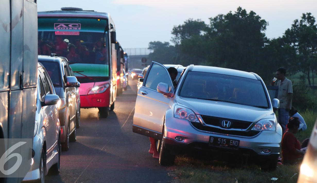 Sejumlah pemudik beristirahat di bahu jalan tol Palikanci, Palimanan, Jabar, Rabu (15/7/2015). Pada puncak arus mudik H-2 Lebaran ribuan kendaraan terjebak macet hingga 38 Km antara jalan tol Cipali hingga tol Palikanci. (Liputan6.com/Herman Zakharia)