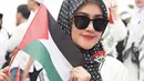 Tidak bersama Tommy Kurniawan, Lisya Nurrahmi hadir dalam aksi bela Palestina bersama rekan selebriti lainnya. Lisya tampil dengan gamis putih, pakai jilbab dengan motif bendera Palestina, dan tak lupa memakai kacamata untuk menghindari silau cahaya matahari. Selain membawa bendera Palestina, Lisya juga mencoret pipi sebelah kanan dengan gambar bendera Palestina. (Liputan6.com/IG/@lisyanurrahmii)
