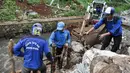 Petugas Tata Air atau pasukan biru membuat pagar untuk penahan saat menambal turap yang longsor di Kalibaru, Desa Putra, Jakarta Selatan, Rabu (22/3). (Liputan6.com/Yoppy Renato)