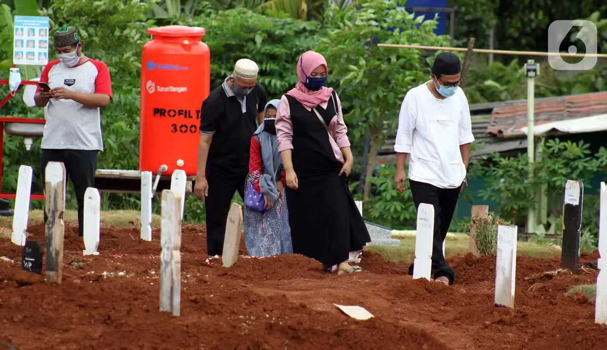 Peziarah berada di area makam jenazah yang diduga terinfeksi virus COVID-19 di TPU Pondok Ranggon, Jakarta, Minggu (24/5/2020). Berdasar data yang diumumkan pemerintah per 24 Mei 2020, 22.271 orang positif Corona, 1.372 meninggal dunia dan 5.402 dinyatakan sembuh. (Liputan6.com/Helmi Fithriansyah)