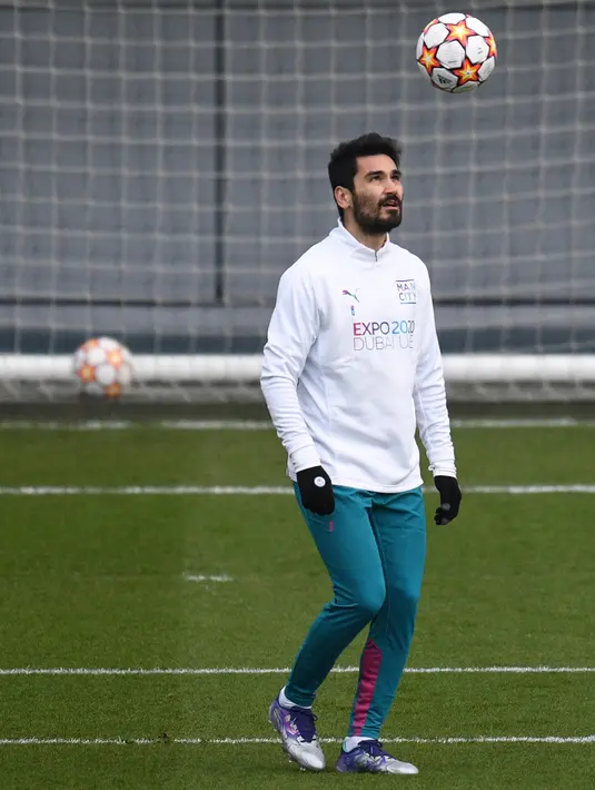 Gelandang Manchester City, Ilkay Gundogan mengontrol bola saat sesi latihan tim di City Football Academy di Manchester, barat laut Inggris (8/3/2022). Pada leg pertama babak 16 Liga Champions, City menang telak atas Sporting CP 5-0. (AFP/Oli Scarff)