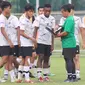 Pelatih Timnas Indonesia U-17, Bima Sakti, memberikan arahan kepada anak asuhnya saat sesi latihan di Lapangan ABC, Kompleks Gelora Bung Karno, Kamis (27/7/2023). (Bola.com/Abdul Aziz)