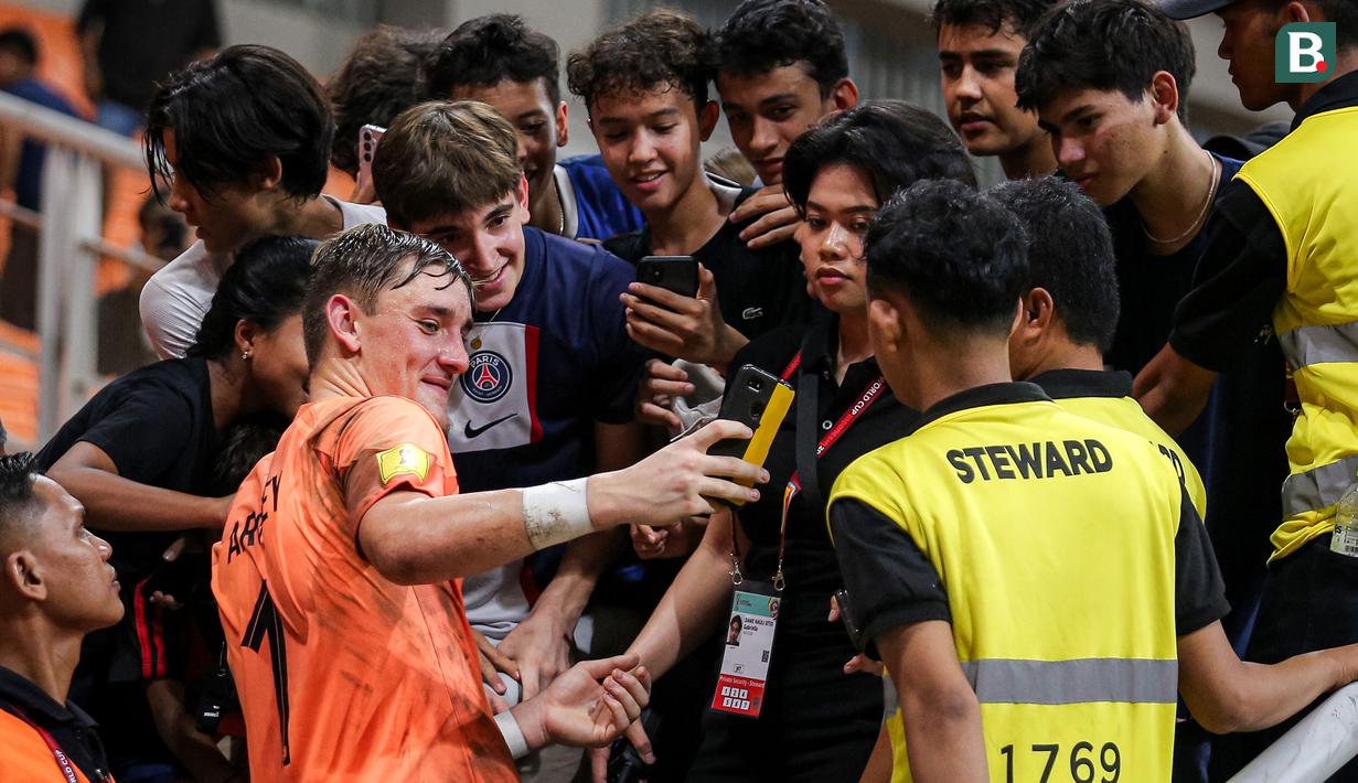 Kiper Timnas Prancis U-17, Paul Argney melayani permintaan selfie para fans setelah mengalahkan Timnas Senegal 5-3 lewat adu penalti pada babak 16 besar Piala Dunia U-17 di Jakarta International Stadium, Jakarta Utara, Rabu (22/22/2023) malam WIB. (Bola.com/Bagaskara Lazuardi)