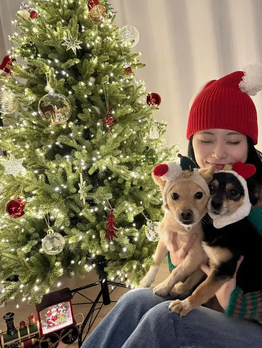 Tzuyu member Twice tampil mengenakan sweater hijau kecoklatan dipadukan celana denim panjang dan bennie warna merah. [@thinkaboutzu]