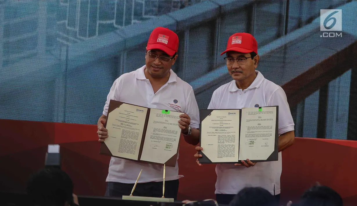 Menteri Perhubungan Budi Karya Sumadi (kiri) bersama Direktur Utama Bank BRI Suprajarto menunjukan MoU kerjasama Sistem Penerbitan Izin Online dan Multimoda (Spionam), E-Ticketing, dan E-Tilang di Jakarta, Minggu (4/3). (Liputan6.com/Faizal Fanani)