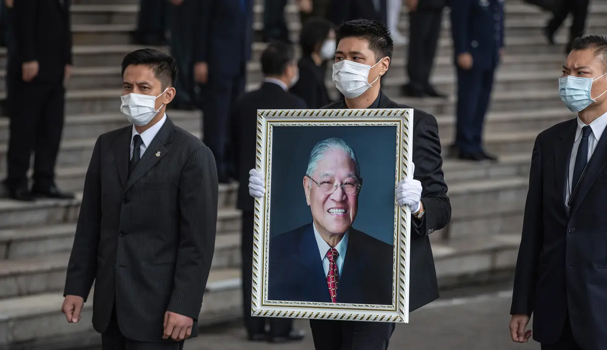 James Zhao, cucu menantu mantan Presiden Taiwan Lee Teng-hui membawa potret Lee saat prosesi pemakaman di Pemakaman Militer Wuzhi Mountain di New Taipei City, Rabu (7/10/2020). Lee, yang dianggap sebagai "bapak demokrasi Taiwan", meninggal Juli lalu di usia 97 tahun. (Military News Agency via AP)