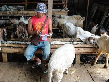 Seorang pedagang mencatat penjualan kambing di Pasar Kambing Tanah Abang, Jakarta, Minggu (11/9). Satu hari jelang Idul Adha 1437 H, pedagang di pasar itu bisa menjual 70-90 ekor per hari dari harga Rp 2 juta hingga 5 juta. (Liputan6.com/Faizal Fanani)