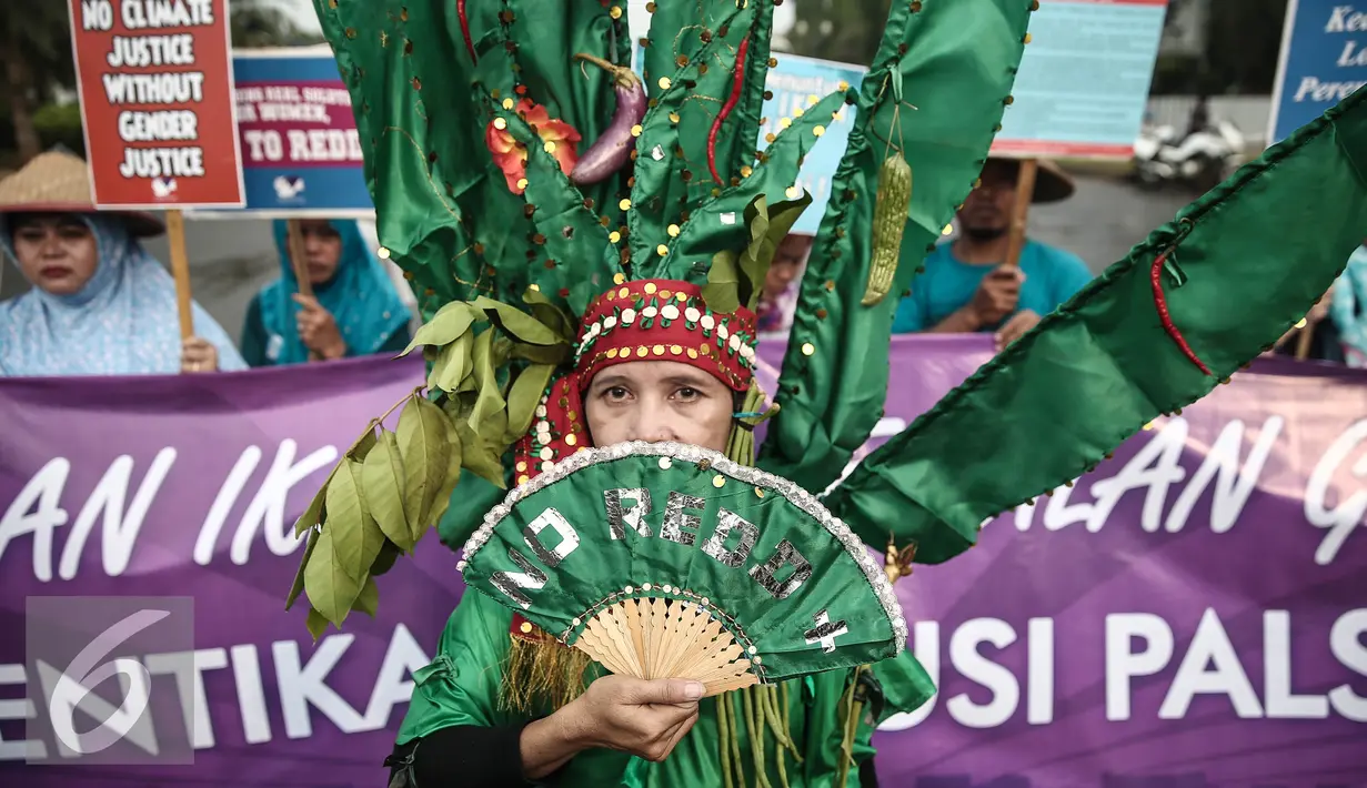 Seorang demonstran berkostum hijau menuntut keadilan iklim di depan Istana Negara, Jakarta, Selasa (17/5). Mereka meminta pemerintah Indonesia tegas dan konsisten dalam langkah mengatasi perubahan iklim. (Liputan6.com/Faizal Fanani)