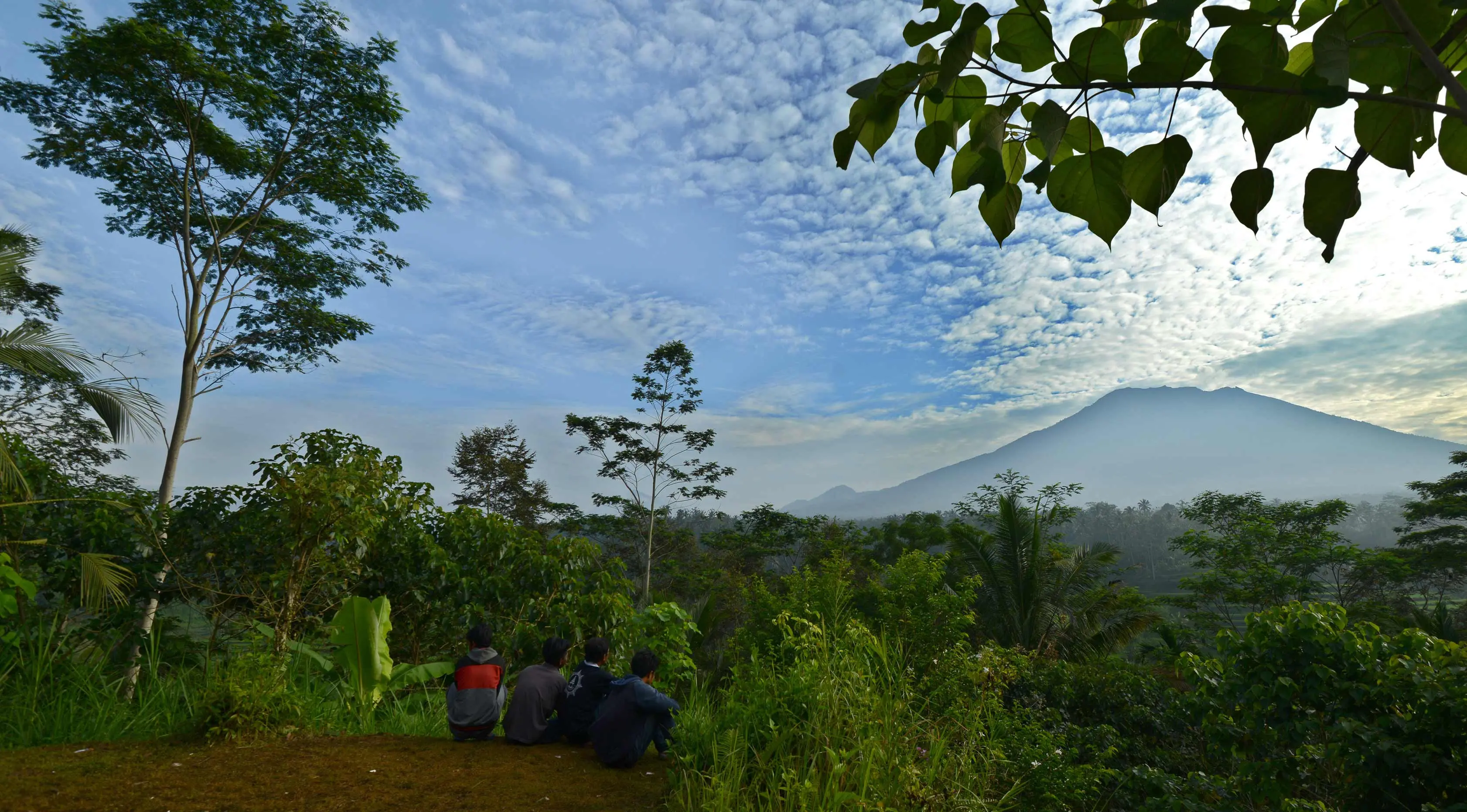 Warga melihat Gunung Agung di Karangasem di pulau resor Bali, Indonesia (24/9).  Gunung Agung kemungkinan akan meletus untuk pertama kalinya sejak lebih 50 tahun lalu. (AFP Photo/Sonny Tumbelaka)