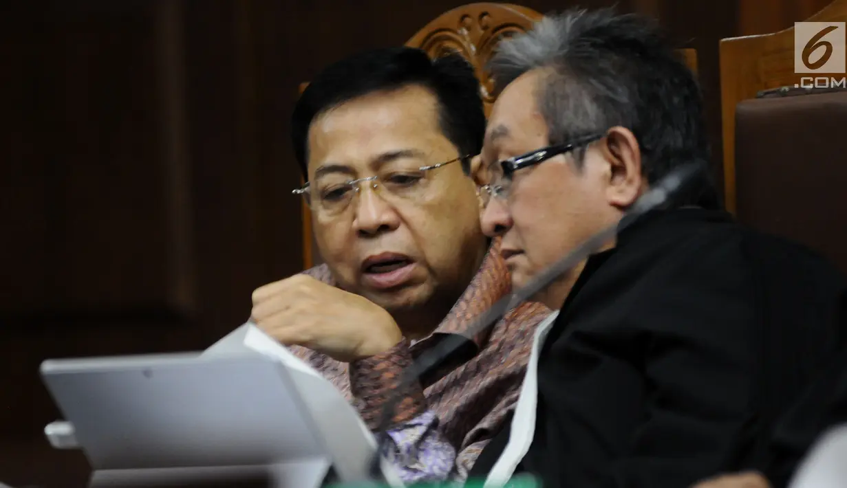 Terdakwa dugaan korupsi proyek e-KTP Setya Novanto (kiri) berbincang dengan kuasa hukumnya saat mengikuti sidang lanjutan di Pengadilan Tipikor, Jakarta, Senin (15/1). Sidang bergaendakan mendengar keterangan saksi. (Liputan6.com/Helmi Fithriansyah)
