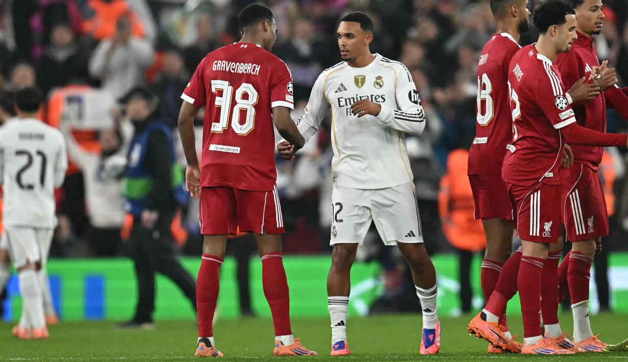 Pemain Real Madrid, Trent Alexander-Arnold (kiri) bersalaman dengan pemain Liverpool, Ryan Gravenberch setelah berakhirnya laga Liga Champions 2025/2026 di Anfield, Liverpool, Inggris, Selasa (04/11/2025) waktu setempat. (AFP/Paul Ellis)