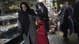 Orang-orang berjalan di bazaar bersejarah tua Teheran, Iran, Minggu (26/2/2023). Beberapa hari terakhir ini antrean panjang tampak di kantor-kantor penukaran mata uang karena banyaknya warga yang berupaya mendapatkan mata uang dolar yang semakin langka. (AP Photo/Vahid Salemi)