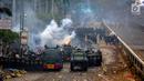 Polisi membuat barikade saat menghalau mahasiswa dalam demonstrasi menolak pengesahan RUU KUHP dan revisi UU KPK di depan Gedung DPR, Jakarta, Selasa (24/9/2019). Semprotan water cannon dan tembakan gas air mata memaksa mahasiswa mundur. (Liputan6.com/Faizal Fanani)