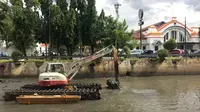 Pekerja menggunakan alat berat untuk mengeruk lumpur dan sampah yang mengendap di anak Sungai Ciliwung, Jakarta, Jumat (26/1). Pengerukan dilakukan untuk mencegah pendangkalan sungai. (Liputan6.com/Immanuel Antonius)