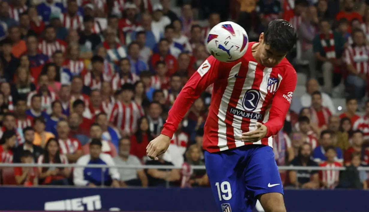 Pemain Atletico Madrid, Alvaro Morata, menyundul bola ke gawang Real Madrid dan membuahkan gol dalam pertandingan pekan keenam La Liga Spanyol 2023/2024 yang berlangsung di Metropolitano stadium, Madrid, Senin (25/9/2023). Pada menit ke-4, Alvaro Morata menyambut umpan silang Samuel Lino di kotak penalti, bola ke sudut kanan bawah. (AFP/Oscar Del Pozo)