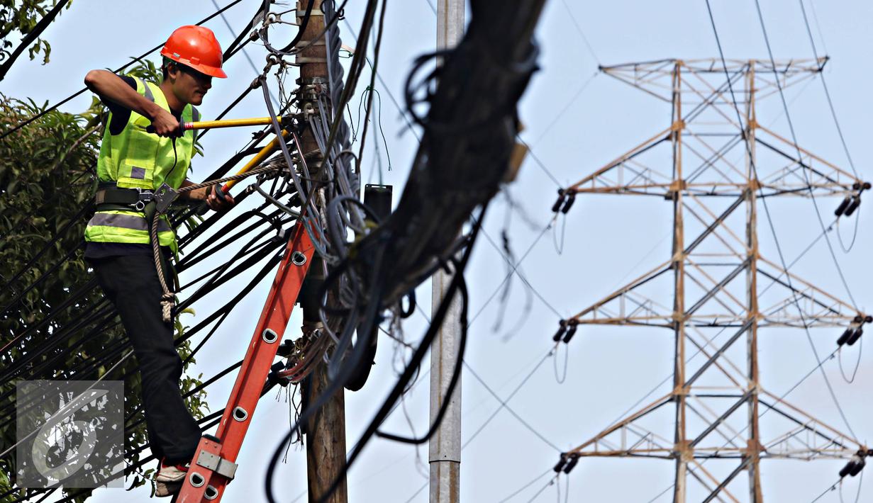 Pekerja mengecek instalasi kabel di tiang listrik milik PLN, Jakarta, Jumat (26/2). PLN menjaga mutu keandalan penyaluran tenaga listrik, memenuhi ketentuan keselamatan ketenagalistrikan, dan estetika tata kota Jakarta. (Liputan6.com/Immanuel Antonius)