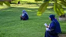 Diketahui, pada dua dekade silam, tepatnya pada 26 Desember 2004, Aceh luluh lantak dihantam gelombang tsunami. Tampak dalam foto, para wanita membaca Al-Quran sambil berdoa untuk kerabat mereka yang meninggal dunia dalam peristiwa gempa dan tsunami Aceh pada 2004 lalu di sebuah kuburan massal di Siron, pada 26 Desember 2025. (CHAIDEER MAHYUDDIN/AFP)