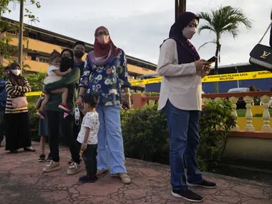 Orang-orang mengantre memasuki TPS untuk memberikan suara mereka selama pemilihan umum (pemilu) di Seberang Perai, negara bagian Penang, Malaysia, Sabtu (19/11/2022). Pemungutan suara untuk Pemilihan Umum ke-15 Malaysia telah dimulai secara resmi hari ini. (AP Photo/Vincent Thian)