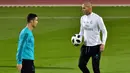 Pelatih Real Madrid, Zinedine Zidane, memberikan instruksi kepada Cristiano Ronaldo saat latihan di Stadion NY University Abu Dhabi, UAE, Senin (11/12/2017). Los Blancos bersiap jelang semifinal FIFA Club World Cup. (AFP/Giuseppe Cacace)