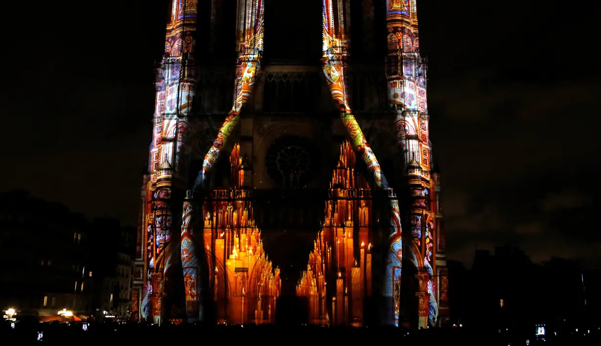 Seni pertunjukan cahaya hiasi Gereja Katedral Notre-Dame de Paris, Prancis (11/11). Pertunjukan cahaya ini menarik banyak wisatawan baik lokal maupun mancanegara. (AFP Photo/Francois Guillot)