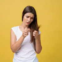 Ilustrasi seorang perempuan yang sedang memegang rambut (Sumber: Freepik.com/benzoix)