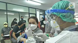 Petugas medis menyiapkan vaksin Covid-19 di Gelanggang Olahraga (GOR) Ciracas, Jakarta Timur, Kamis (24/6/2021).  Pelaksanaan vaksinasi dimulai Kamis, 24 Juni 2021 dengan target 1000 vaksin per hari. (Liputan6.com/Herman Zakharia)