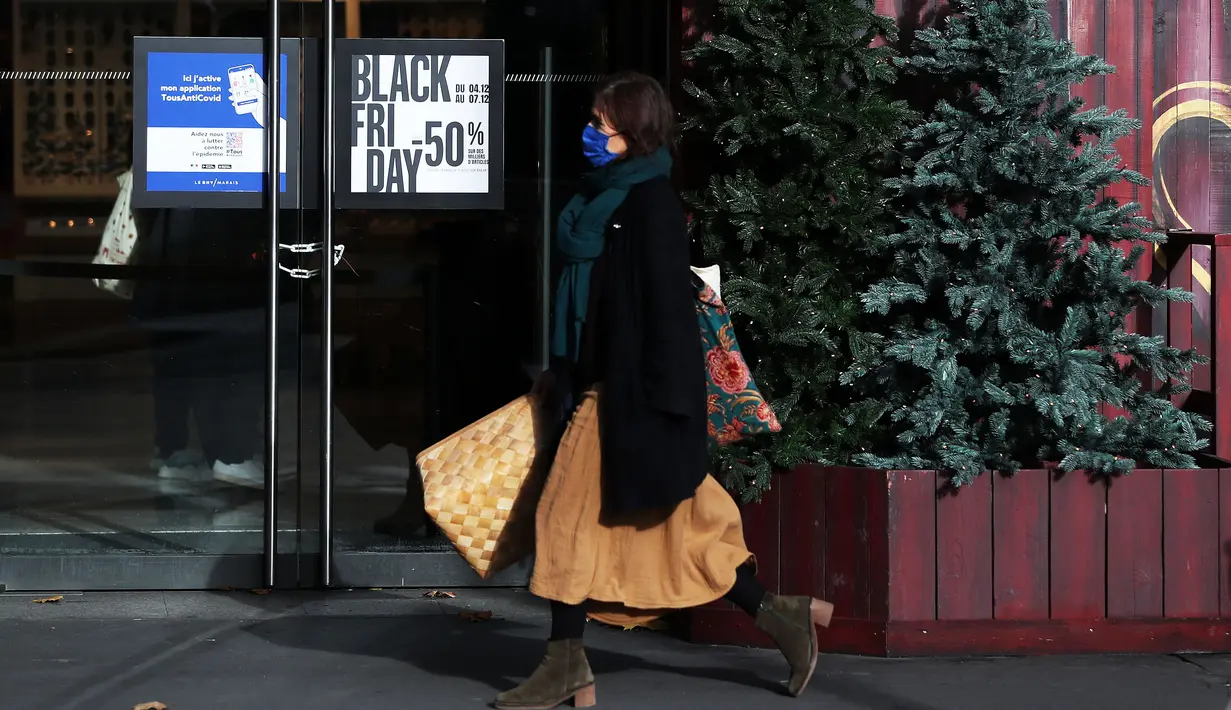 Seorang perempuan berjalan melewati poster "Black Friday" di Paris, Prancis, pada 4 Desember 2020. Sempat ditunda selama sepekan akibat karantina wilayah (lockdown) nasional, pesta belanja tahunan "Black Friday" di Prancis akhirnya dimulai pada Jumat (4/12). (Xinhua/Gao Jing)