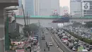 Kendaraan melintas berlatar pembangunan bentangan beton lintasan LRT di Jalan Gatot Subroto Jakarta, Kamis (7/11/2019). Saat ini pembangunan tiang pancang yang membentang di atas ruas jalan tol tersebut sudah tersambung. (Liputan6.com/Immanuel Antonius)