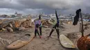 Warga Palestina, Khalil Abu Jayyab (kanan) dan Tahseen Abu Assi melakukan pemanasan sebelum berselancar di pantai Kota Gaza, Minggu, 28 Desember 2025. Pasca diberlakukannya gencatan senjata fase pertama yang didukung oleh Amerika Serikat mulai berlaku pada 10 Oktober 2025, warga Palestina mulai kembali ke Kota Gaza. (AP Photo/Jehad Alshrafi)