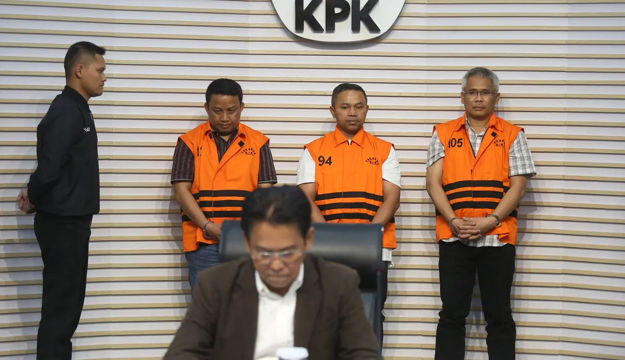 Gubernur Riau Abdul Wahid (kedua kanan belakang) menggunakan rompi tahanan saat dihadirkan pada rilis penetapan sekaligus penahanan usai menjalani pemeriksaan di Gedung Merah Putih Komisi Pemberantasan Korupsi (KPK), Jakarta, Rabu (5/11/2025). Selain Abdul Wahid, KPK juga menahan dua tersangka lainnya, yaitu Kepala Dinas PUPR-PKPP Muhammad Arief Setiawan dan Sekretaris Dinas PUPR-PKPP Ferry Yunanda. (merdeka.com/Arie Basuki)