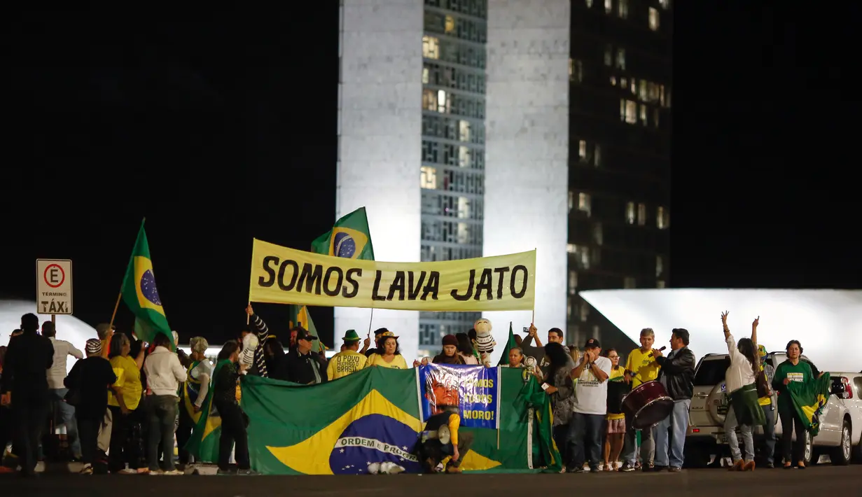 Warga turun ke jalan merayakan keputusan Hakim menjatuhkan hukuman ke mantan Presiden Brasil Luiz Inacio Lula da Silva di Rio de Janeiro, Brasil (12/7). Silva memerintah Brasil dari 2003-2010. (AFP Photo/Sergio Lima)