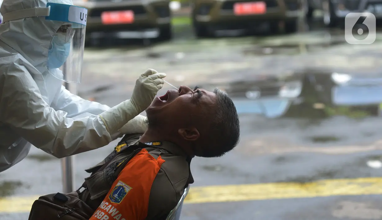Petugas medis mengambil sampel lendir saat tes usap (swab test) pegawai kecamatan Sawah Besar, Jakarta, Selasa (18/8/2020). Tes swab yang dilakukan terhadap seluruh pegawai kecamatan Sawah Besar itu sebagai upaya memutus mata rantai penyebaran Virus Corona Covid-19. (merdeka.com/Imam Buhori)