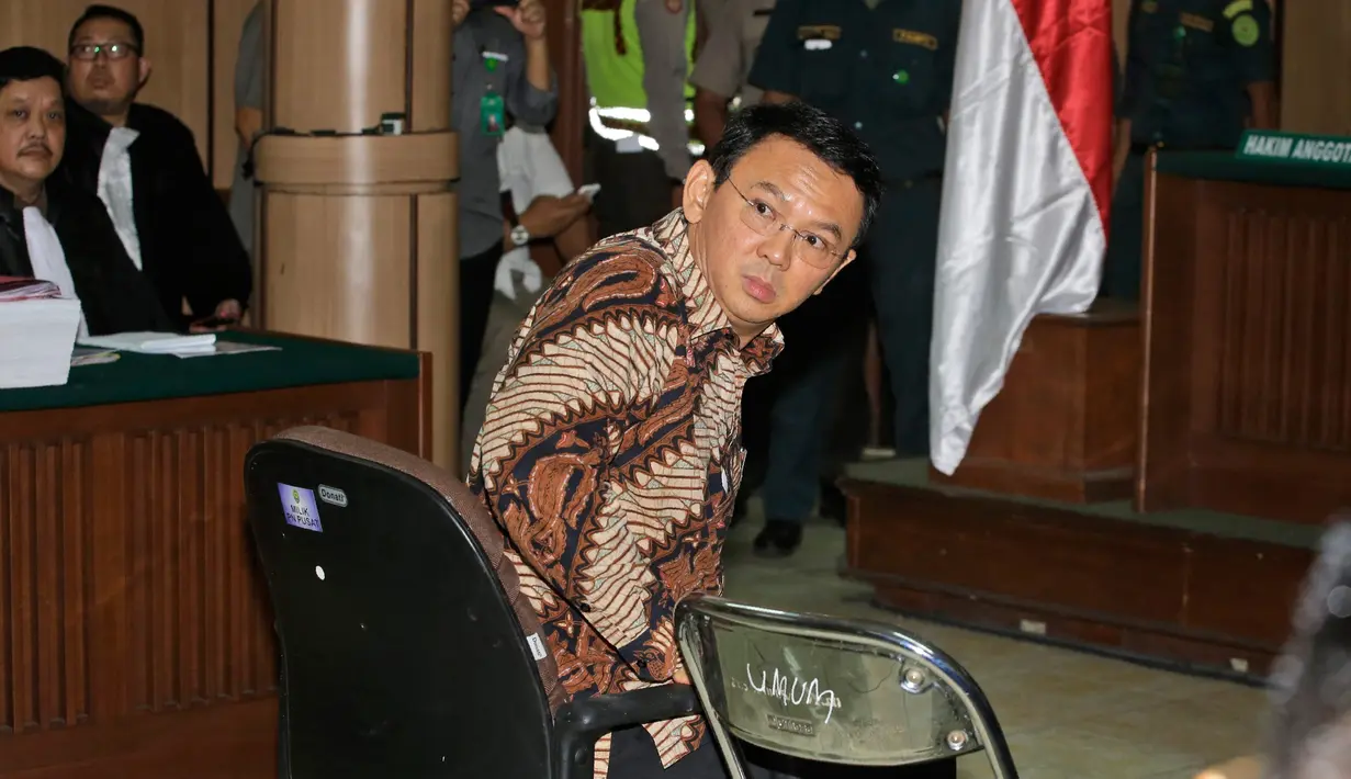 Basuki Tjahaja Purnama atau Ahok melihat ke arah fotografer sesaat sebelum menjalani sidang perdana kasus dugaan penistaan agama di PN Jakarta Utara, Selasa (13/12). Sidang hari ini beragenda pembacaan surat dakwaan dari tim JPU. (TATAN SYUFLANA/POOL/AFP)