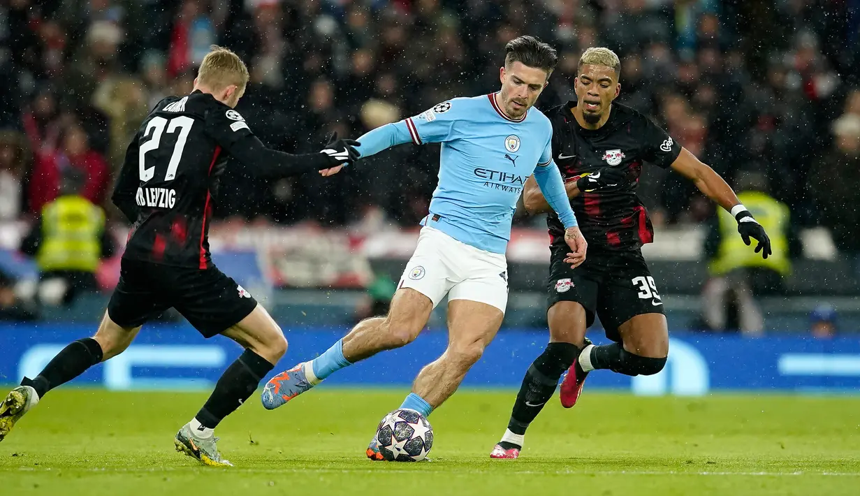 Pemain RB Leipzig Konrad Laimer (kiri) dan Benjamin Henrichs (kanan) berebut bola dengan pemain Manchester City Jack Grealish (tengah) pada pertandingan sepak bola leg kedua babak 16 besar Liga Champions di Etihad Stadium, Manchester, Inggris, 14 Maret 2023. Laga berakhir 7-0 dan membawa Manchester City lolos ke perempat final Liga Champions dengan agregat 8-1. (AP Photo/Dave Thompson)