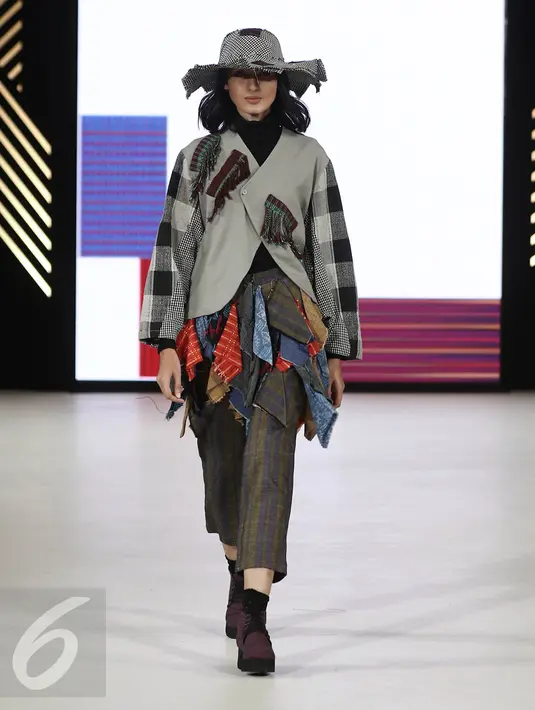 Model menampilkan busana rancangan Amanda Indah Lestari di panggung Senayan City Fashion Nation ke-11, Jakarta, Rabu (12/4). Lewat label fesyen Lekat, Amanda memamerkan cuplikan koleksi fall/winter 2017 dengan tenun baduy. (Liputan6.com/Herman Zakharia)