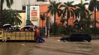 Sejumlah orang menaiki truk untuk melewati banjir di depan Mal Kelapa Gading, Jakarta Utara, Selasa (10/2/2015). (Axel Widjaja)