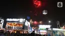 Pengunjung menyaksikan pesta kembang api di langit saat Jakarta Fair ke-53 atau Pekan Raya Jakarta (PRJ) di JiExpo Kemayoran, Jakarta Pusat, Selasa (21/6/2022) malam. Pesta kembang api menggelegar di kawasan PRJ bertepatan dengan HUT Jakarta yang jatuh pada besok, 22 Juni 2022. (Liputan6.com/Herman Zakharia)