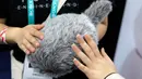 Pengunjung memegang robot Qoobo saat pameran teknologi CES 2020 di Las Vegas, Amerika Serikat, Minggu (5/1/2020). Qoobo dapat mengibaskan ekornya saat dibelai. (AP Photo/John Locher)