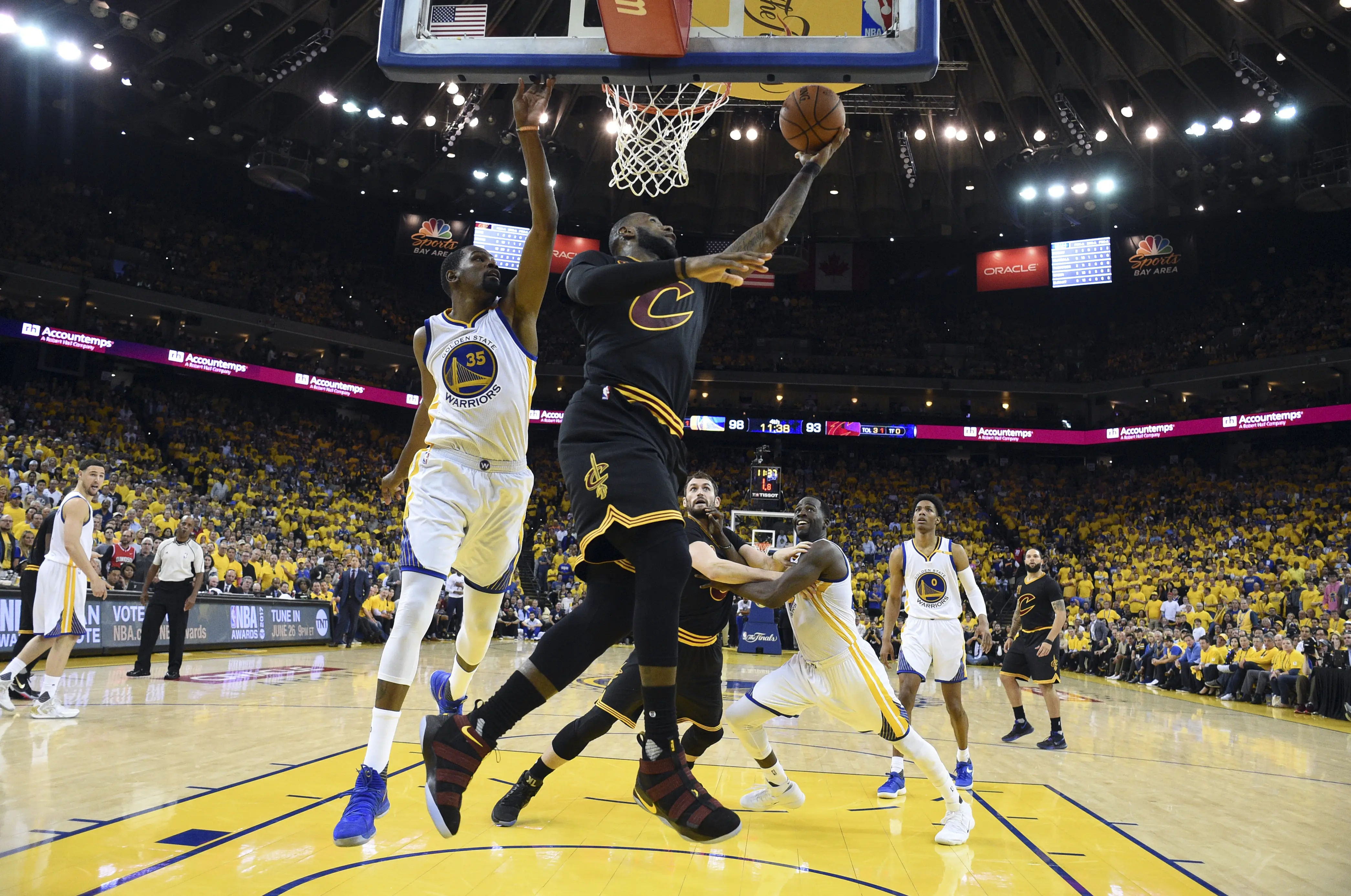 Forward Cleveland Cavaliers, LeBron James, memasukkan bola pada gim 5 final NBA 2017 melawan Golden State Warriors di Oracle Arena, Selasa (13/6/2017) siang WIB. Cavaliers kalah 120-129 dan menyerah 1-4. (AP Photo/Kyle Terada)